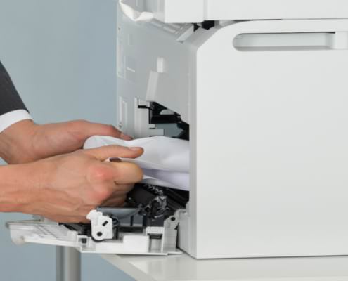 Achten Sie darauf, dass Sie den Papierstau richtig entfernen. Ziehen Sie das Papier mit der Laufrichtung aus dem Drucker oder Kopierer.