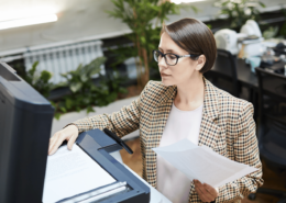 Mitarbeiter scannt Geschäftsunterlagen mit moderner Scanlösung in einem digitalisierten Büro