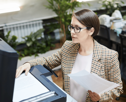 Mitarbeiter scannt Geschäftsunterlagen mit moderner Scanlösung in einem digitalisierten Büro